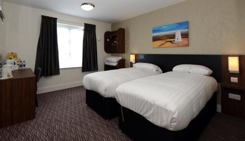 a hotel room with two beds and a window at Fallow Field, Telford by Marston's Inns in Telford