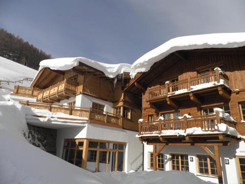 a building covered in snow with snow on the roof at Andis Almdorf in Sölden