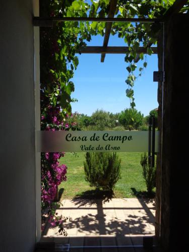 an open door to a garden with the words case de campagna take the game at Casa de Campo Vale do Asno in Altura