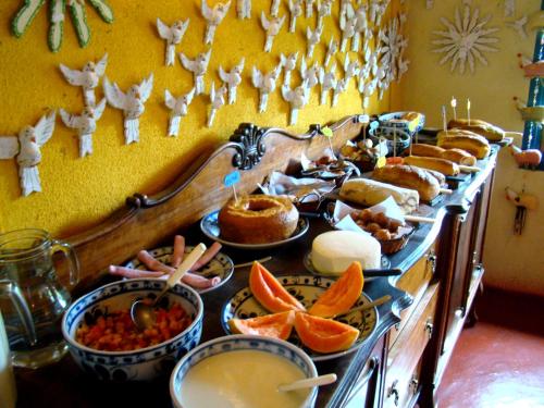 a buffet of food with oranges and other foods at Pousada Trem das Cores in Gonçalves