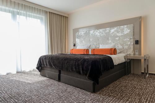 a bedroom with a large bed with orange pillows at Le Chateau Des Thermes in Chaudfontaine