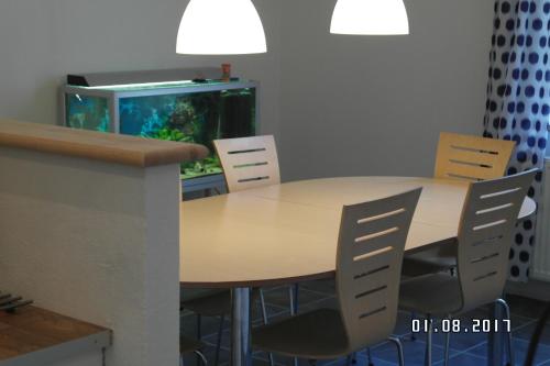 a dining room table with chairs and an aquarium at Ringslund B&B in Galten