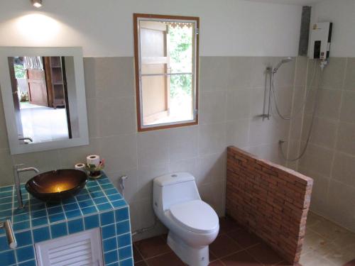 La salle de bains est pourvue de toilettes et d'un lavabo. dans l'établissement Happiness Resort Sukhothai, à Sukhothaï