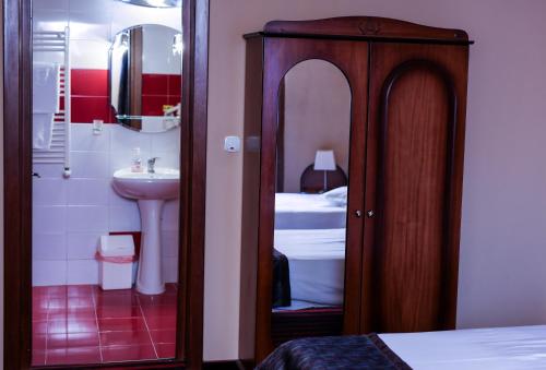 a small bathroom with a sink and a mirror at Hotel Atlantic in Adjud