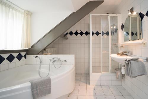 
a bathroom with a sink, toilet and bathtub at Herberg Restaurant 't Zwaantje in Mook
