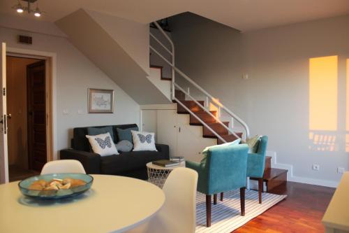 a living room with a table and a staircase at Sea & Fish apartments in Matosinhos
