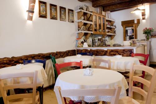 un comedor con mesas y sillas blancas en Garnì La Rua nel Bosco en Rivisondoli