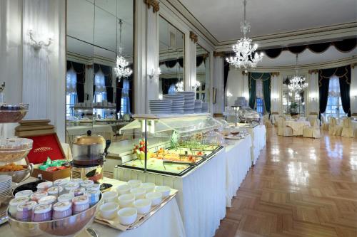 a buffet line with food on display in a room at Eurostars Hotel Excelsior in Naples
