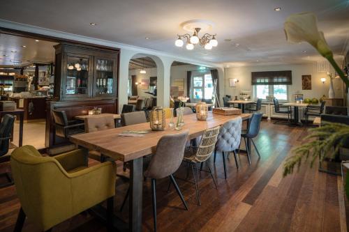MookにあるHerberg Restaurant 't Zwaantjeのダイニングルーム(大きな木製テーブル、椅子付)