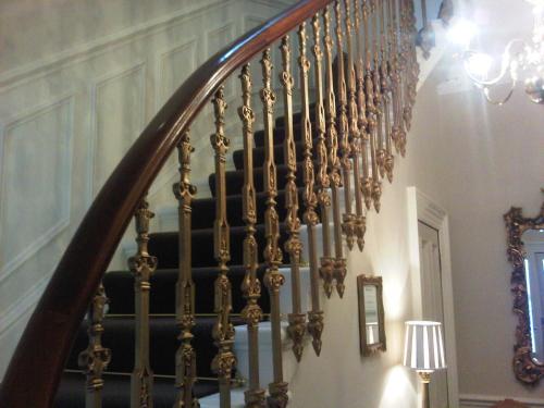 a spiral staircase in a home with a chandelier at Highfield Guest House in Edinburgh