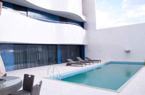 a swimming pool in a building with chairs around it at Rapport Hotel in Juazeiro