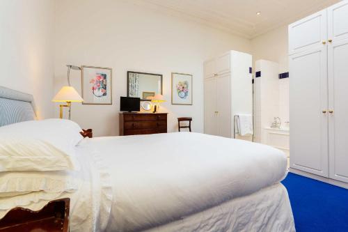 - une grande chambre blanche avec un grand lit blanc dans l'établissement Veeve - Queen's Gardens Flat, à Londres