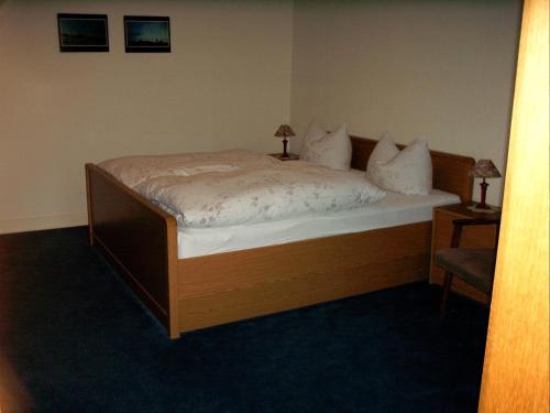 a bedroom with a bed and a chair at Gasthof Haus Hubertus in Winterberg