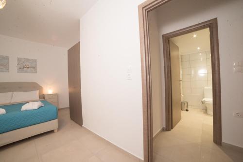 a bedroom with a bed and a bathroom with a mirror at Bella Mare Luxury Apartments in Kalamaki Heraklion