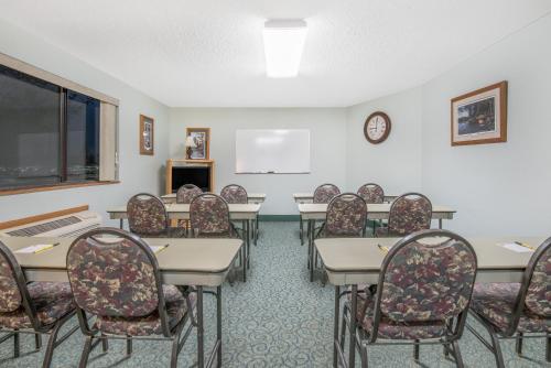 a conference room with tables and chairs and a screen at I M Hotel by Timberlake in Grand Rapids