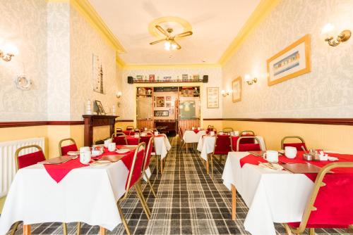 un restaurant avec des tables et des chaises rouges et blanches dans l'établissement Valdene Hotel, à Blackpool