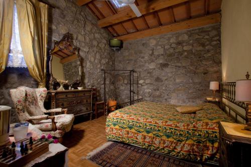 1 dormitorio con cama y pared de piedra en Agriturismo Biologico La Buona Terra, en Villa Marin