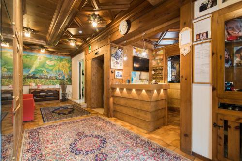 a living room with wooden walls and a large rug at Hotel Ferrovia in Calalzo