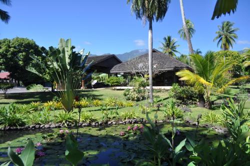 a garden with a pond in front of a house at Royal Tahitien in Papeete