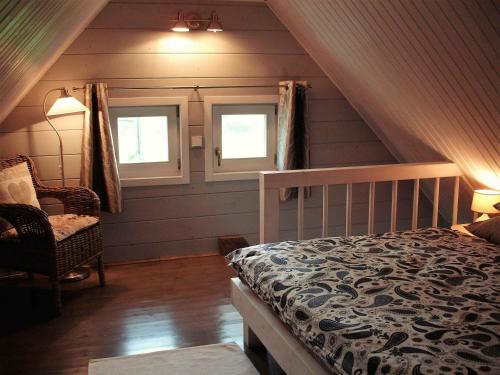 a attic bedroom with a bed and two windows at Sofia Chalet in Bublava