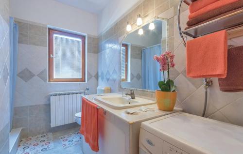 a bathroom with a sink and a toilet and a mirror at Apartments Klaudija in Pula