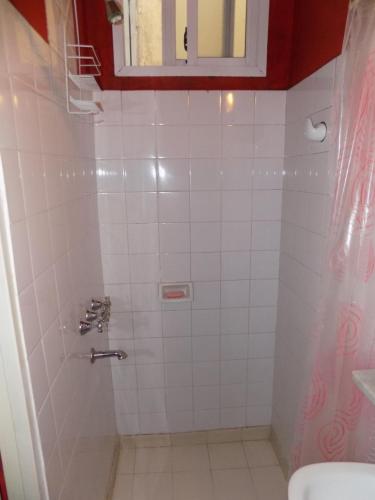 baño con ducha de azulejos blancos y ventana en Casa de Familia - Solo Para Mujeres *Woman ONLY* en Buenos Aires