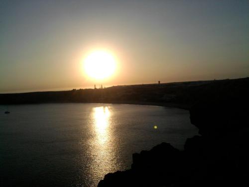 a sun setting over a body of water at Casa do Cabo de Santa Maria in Sagres