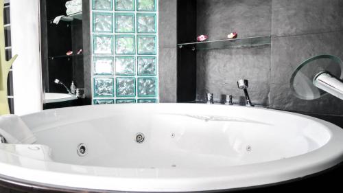 a white bath tub in a bathroom with a mirror at Black and White Suitte "Marques" in Noja
