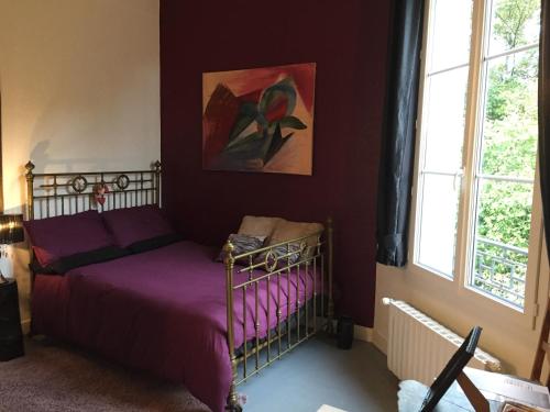 - une chambre avec un lit doté de draps violets et de fenêtres dans l'établissement Chateau Anaselle, à Condé-sur-Noireau