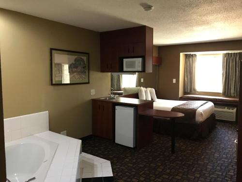 a hotel room with a bed and a bath tub at Microtel Inn & Suites by Wyndham Lithonia/Stone Mountain in Lithonia