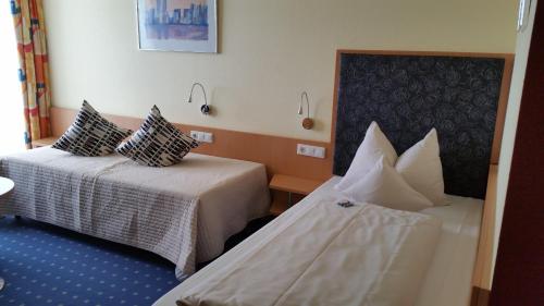 a hotel room with two beds with pillows at Hotel Ifen in Wiesloch