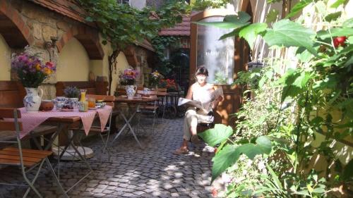 a man sitting on a chair in a garden at Hotel Schlossberg in Meißen