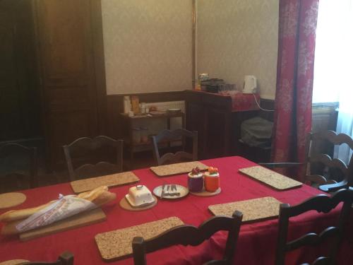 een eetkamer met een tafel met een rood tafelkleed bij Chez Susan in Buzy