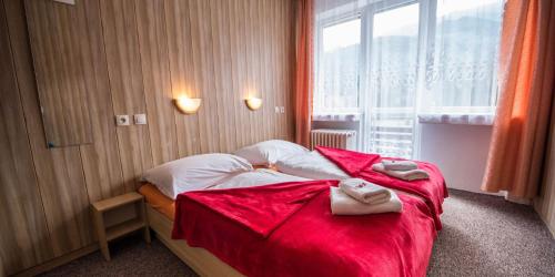 Hotel Magura في زديار: غرفة نوم عليها سرير وفوط