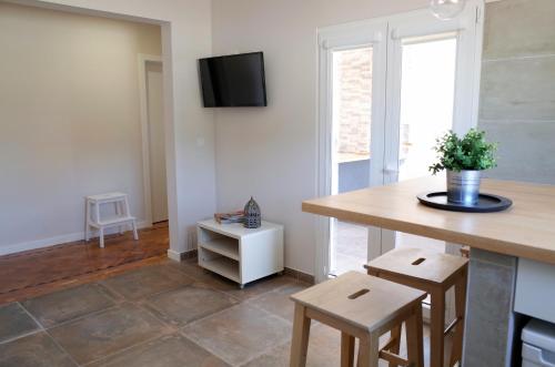 a kitchen with a table and chairs and a tv on the wall at Lisbon Beach Apartments 2 in Costa da Caparica