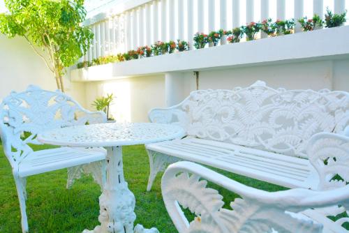 a white bench and a table in the grass at Hotel Terra do Sol in Aracaju