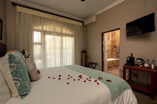 a bedroom with a bed with red roses on it at Leopardsong Manor in Centurion