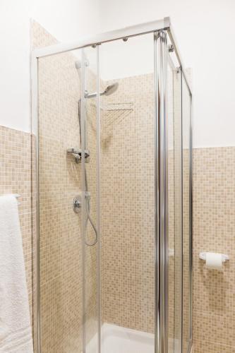 a shower with a glass door in a bathroom at Floreo Guest House in Rome