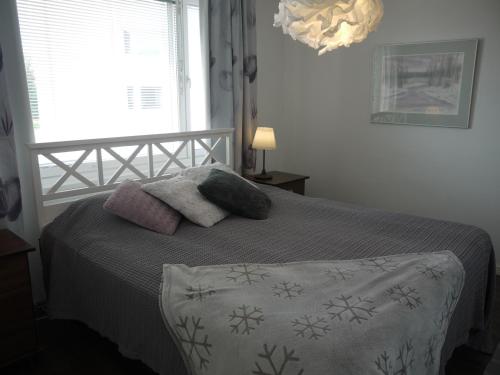 a bedroom with a bed with two pillows and a window at Apartment Skylights in Rovaniemi