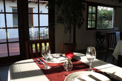 a table with two wine glasses and a rose on it at La Quinta San Andrés in Ibarra