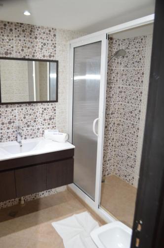 y baño con ducha y lavamanos. en Anezi Apartments, en Agadir
