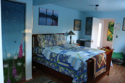 1 dormitorio con 1 cama con pared azul en Sunshine House Bed and Breakfast, en Seward