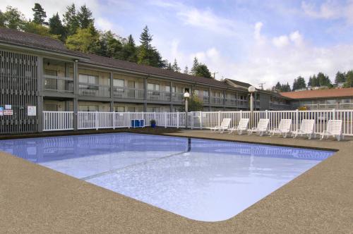 a swimming pool in front of a building with chairs at Red Lion Hotel Coos Bay in Coos Bay