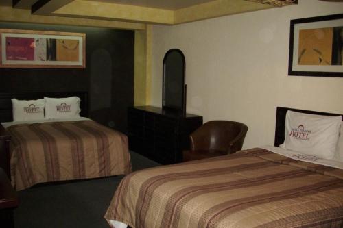 a hotel room with two beds and a chair at Sunio City in Tijuana