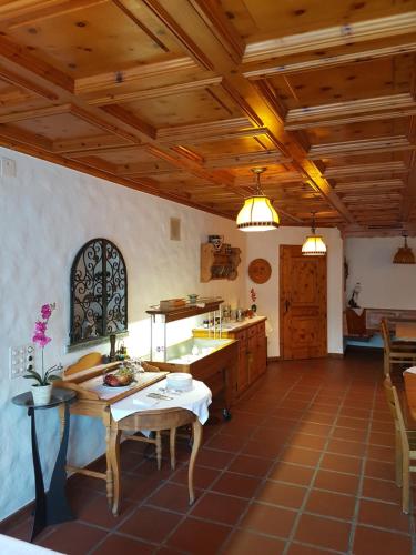 a large kitchen with wooden ceilings and a table at Bed and Breakfast Krone in Schellenberg