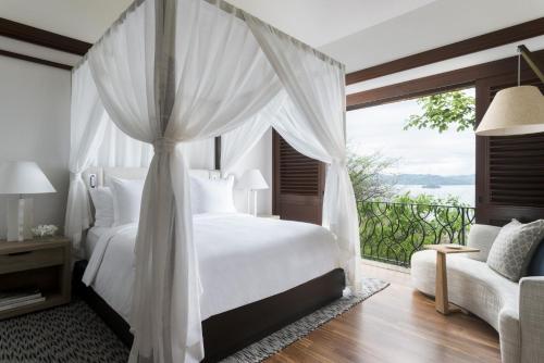 ein Schlafzimmer mit einem weißen Bett und einem großen Fenster in der Unterkunft Four Seasons Resort Peninsula Papagayo, Costa Rica in Culebra