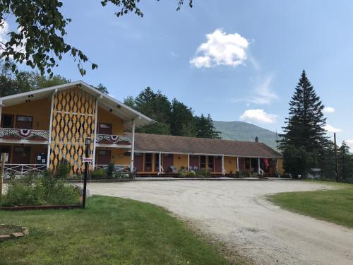 a large building with a dirt road in front of it at Snowdon Chalet Motel in Londonderry