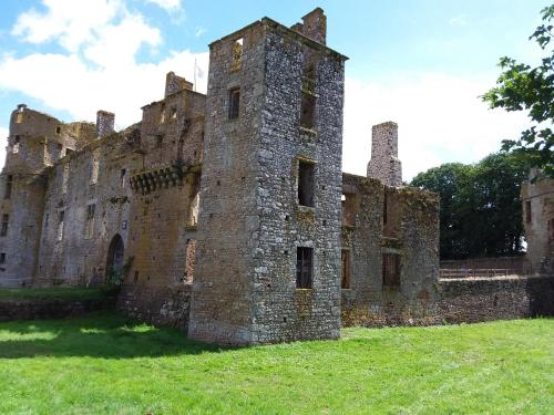an old castle sitting on a field of grass at L'Orchidée in Lassay