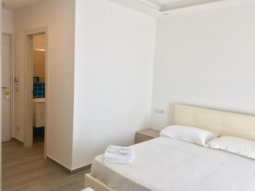 een witte slaapkamer met een bed en een hal bij Klaton Beach Hotel in Formia