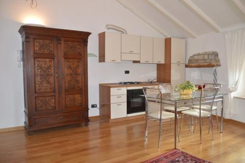 a kitchen with a table and chairs and a kitchen with a cabinet at Apartments Boscarin in Buje